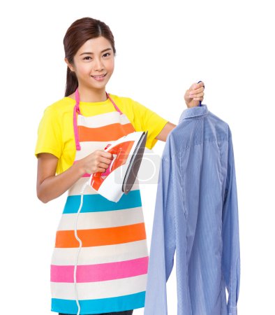 Housewife holding iron steamer with shirt