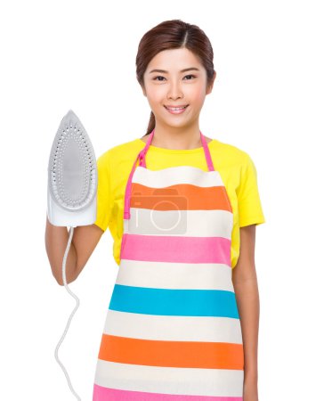 Housewife in apron with iron