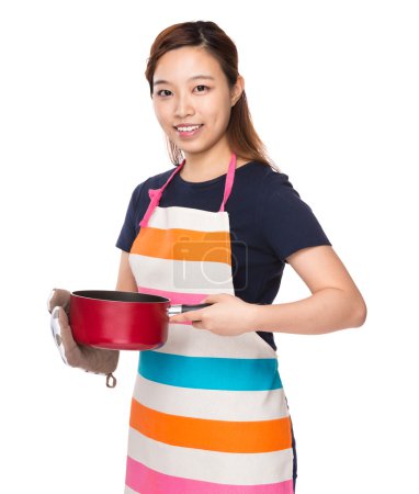 Asian Housewife holding saucepan with oven gloves