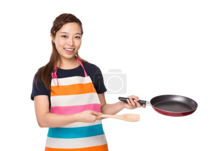 Housewife hold with pan and wooden ladle