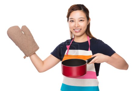 Housewife with saucepan and oven gloves