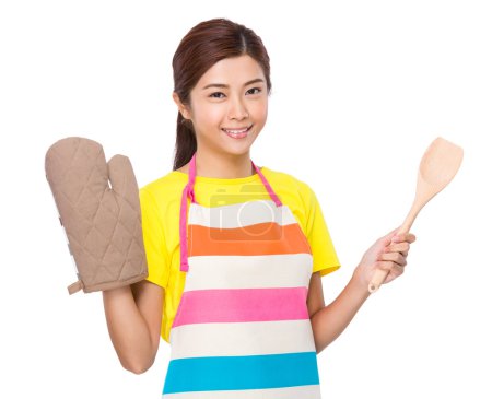 Housewife with oven gloves and wooden ladle