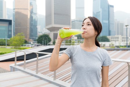 Sporty woman drinking vegetable beverage