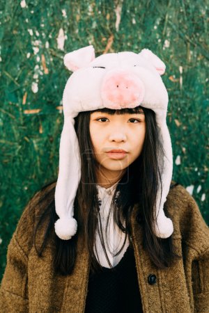 女人穿着滑稽的小猪冬帽