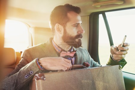 坐在车的后座上的商人