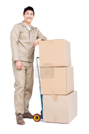 Deliveryman standing beside luggage trolley