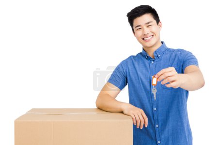 Man leaning on box and holding key