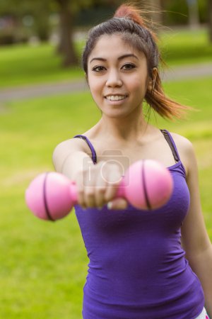 Woman lifting dumbbell in park