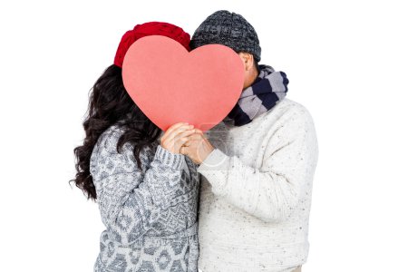 Couple hiding behind heart shape cardboard