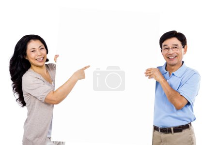 Smiling couple holding up a large sign