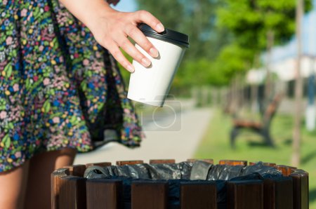 特写女性手扔垃圾纸杯