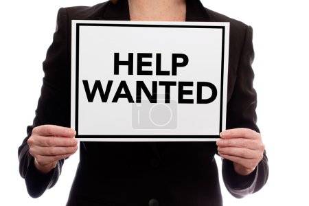 in a business suit holding a piece of paper saying "help wanted"