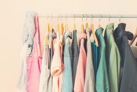 Pastel Color Female Clothes in a Row on Open Hangerl. Toned