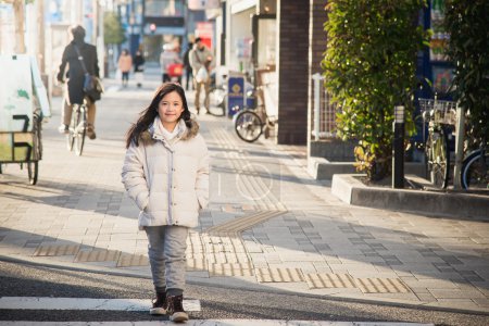 Beautiful asian girl waking in the street.