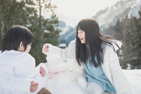  Asian children playing with snowman