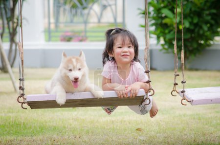 Asian baby  baby on swing with puppy