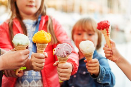 5 corns of colorful ice cream holding by kids