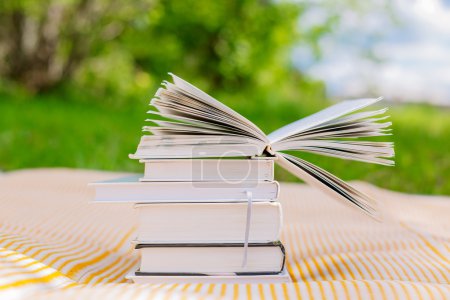 打开绿色和红色的书堆上的书