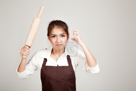 Asian Baker woman  in apron  with wooden rolling pin