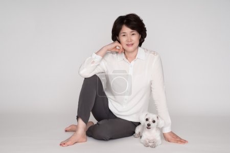 Portrait of beautiful mature woman posing against gray background