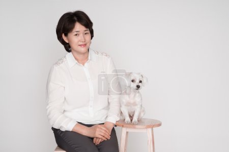 Portrait of beautiful mature woman posing against gray background