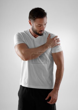 年轻随便的人,抱着他的衬衫在他的肩上